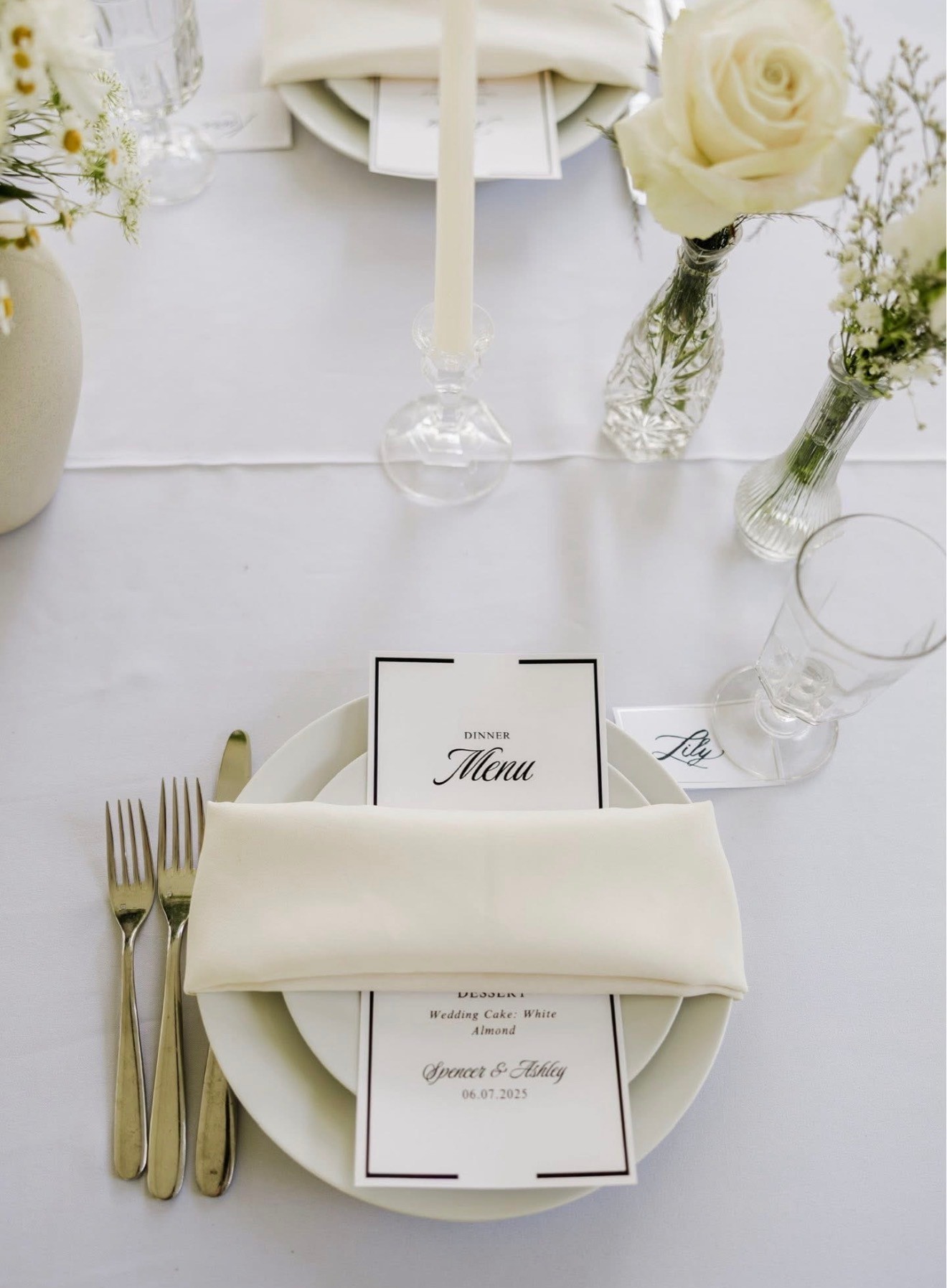 A place setting with a printed dinner menu tucked into a cream napkin