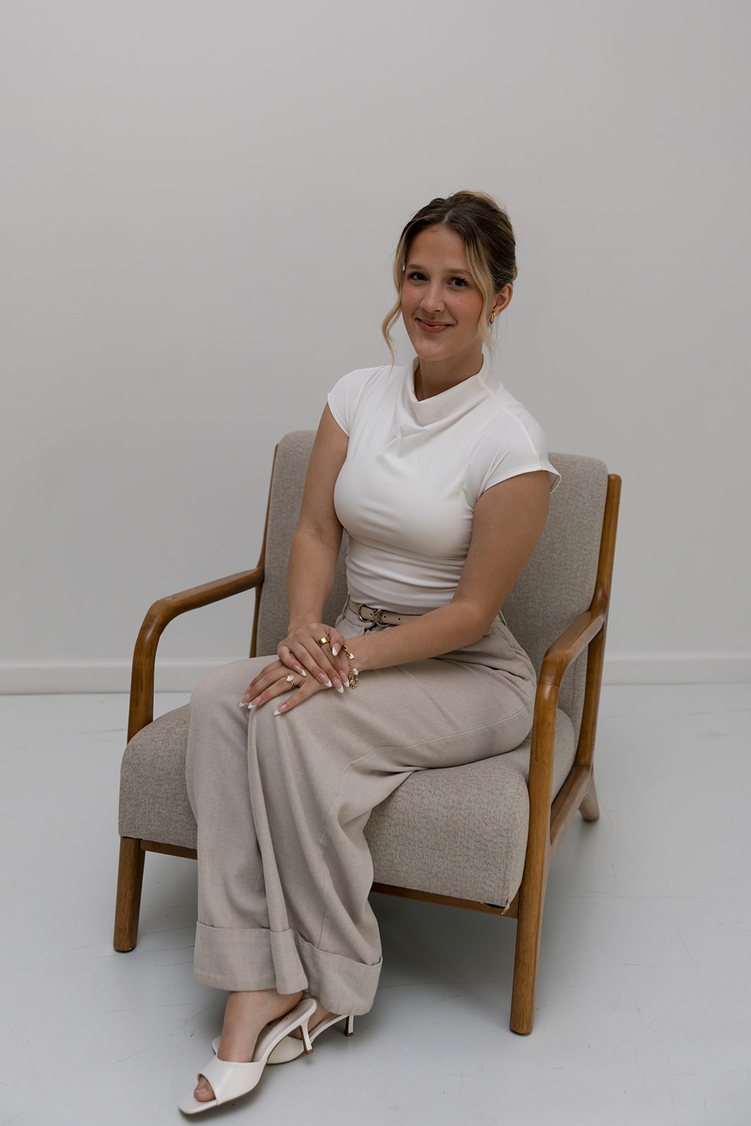 Ashlyn Arroyo seated in a wooden armchair, smiling