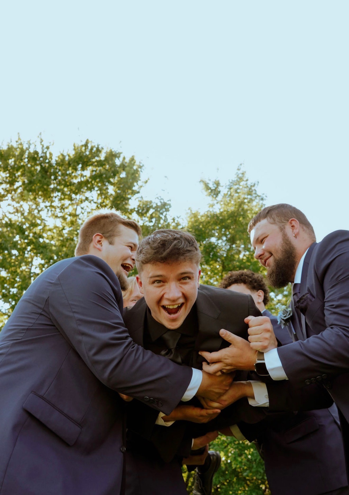 Groomsmen hug and laugh with the groom before the ceremony
